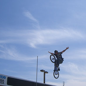 A bicycle stunt with outstretched arms like wings