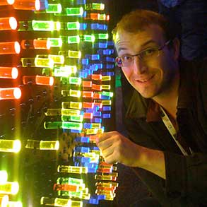 Portrait of a programmer next to an over-sized Lite-Brite at the Google I/O conference