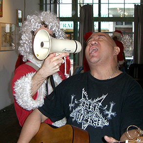 A band of Santas came roaming through my art show and lent a megaphone to a guitarist