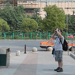 A tourist in Shanghai takes a picture of something up high
